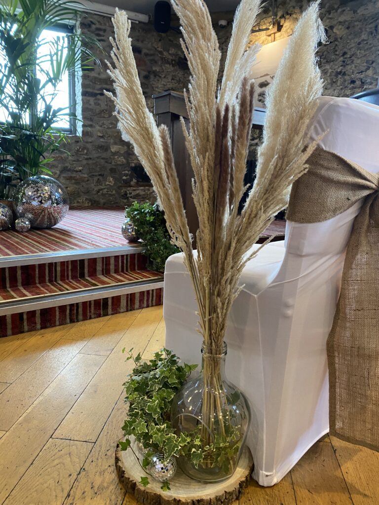 Wedding floor décor with pampas grass arrangement, greenery and mirrored spheres