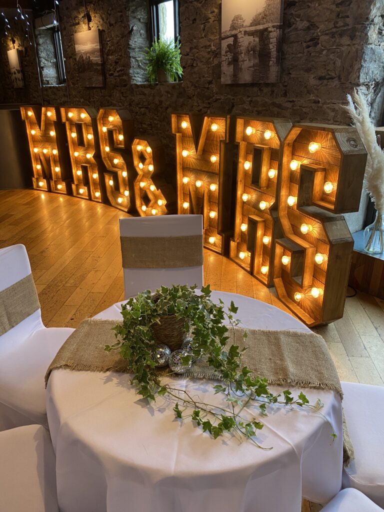 Sweetheart wedding table with greenery runner and illuminated MR & MRS letters