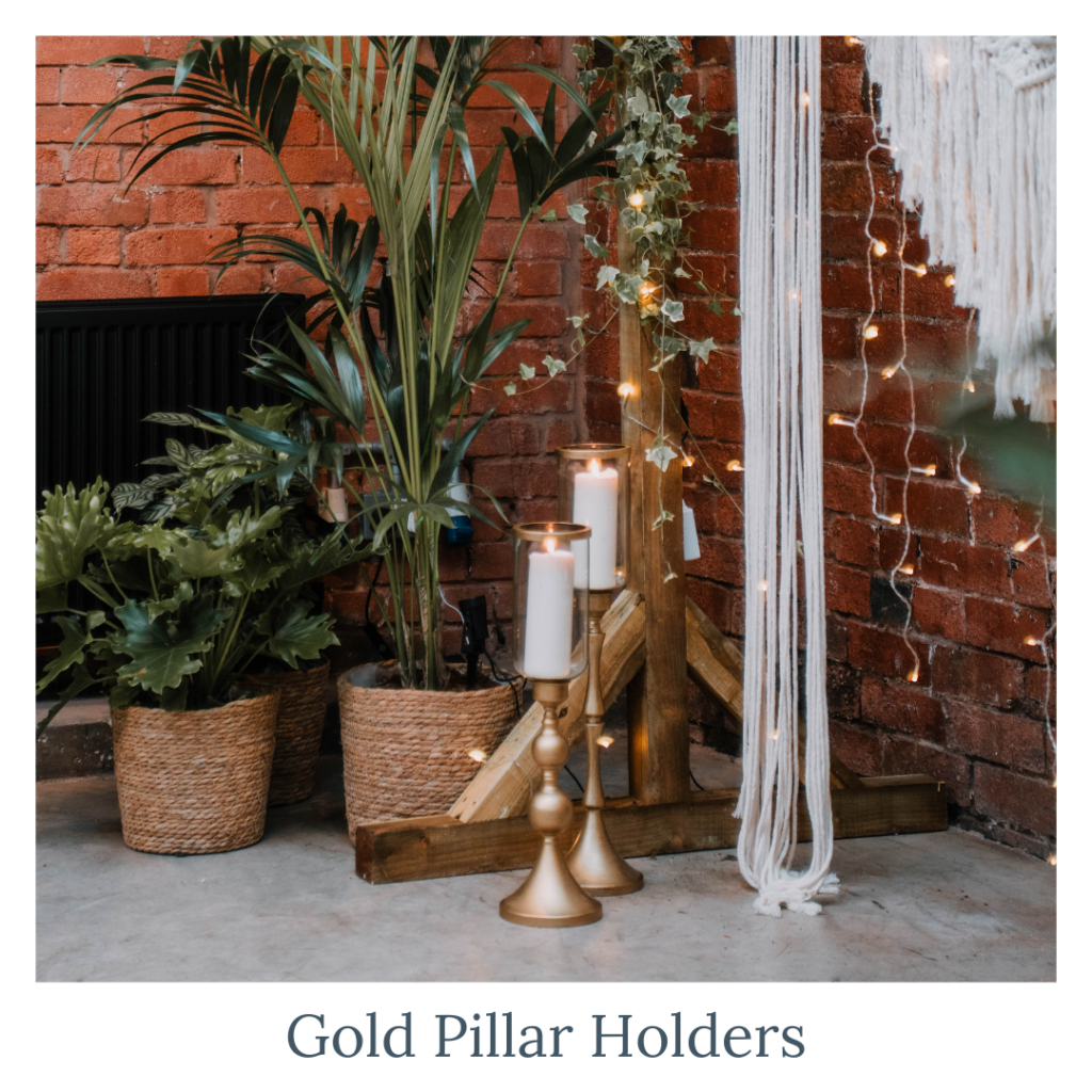 Gold pillar candle holders with glass vases for elegant wedding décor styling