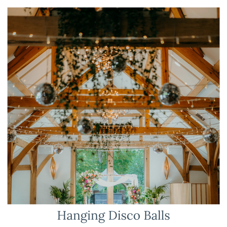Hanging disco balls with greenery for wedding ceiling décor and venue styling