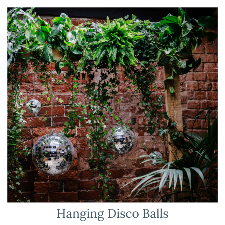 Disco balls hanging with foliage for modern wedding décor and styling