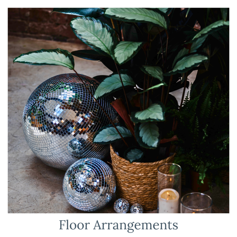Wedding floor arrangements with disco balls, plants, and candle décor
