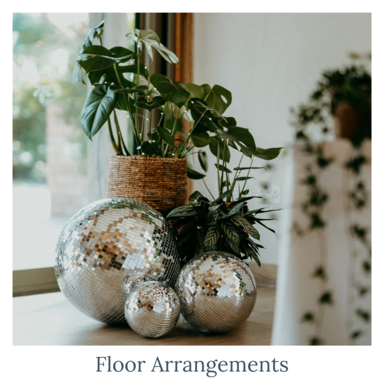 Botanical wedding floor arrangements with disco balls and greenery