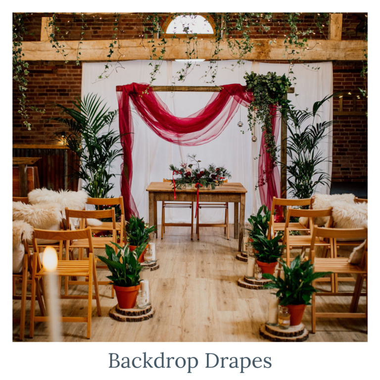 Wedding ceremony backdrop with coloured draping and greenery