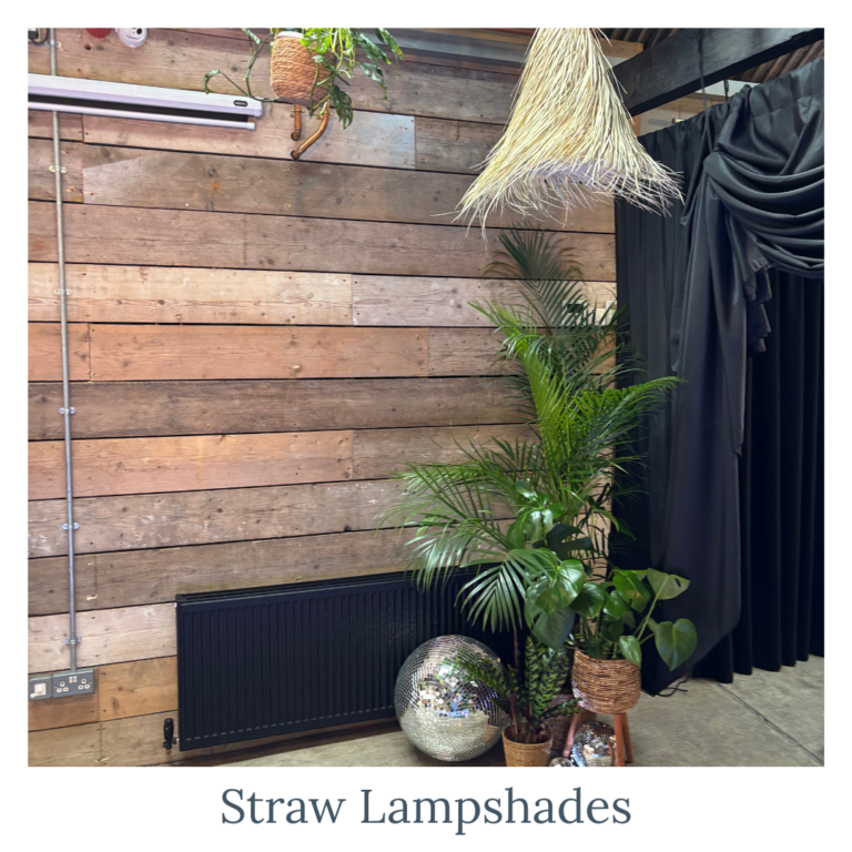 Straw lampshades hanging as rustic wedding décor lighting paired with foliage and discoballs
