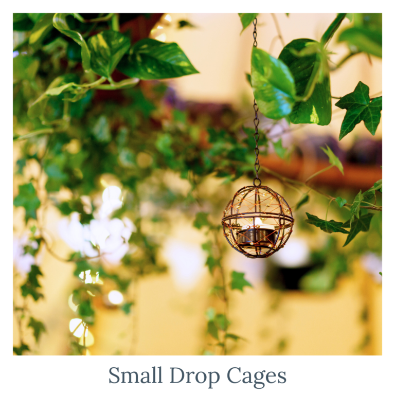 Small drop cage candle holders styled with greenery for wedding décor