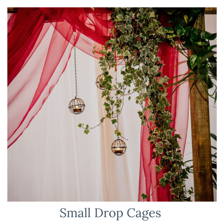 Small drop cage candle holders styled with greenery for wedding décor.