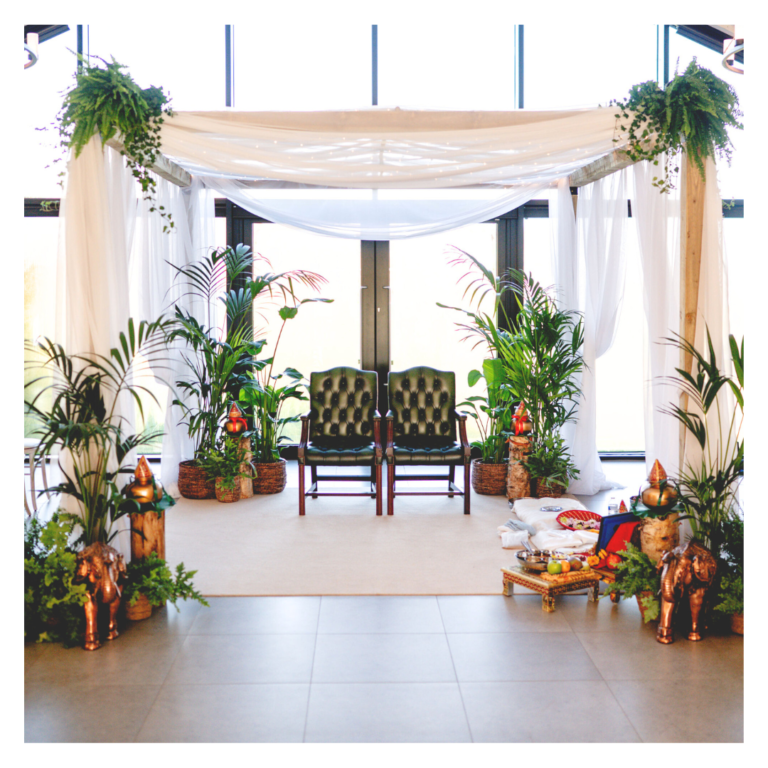 Botanical wedding mandap hire with white draping, fairy lights and lush greenery, ready for a Hindu ceremony