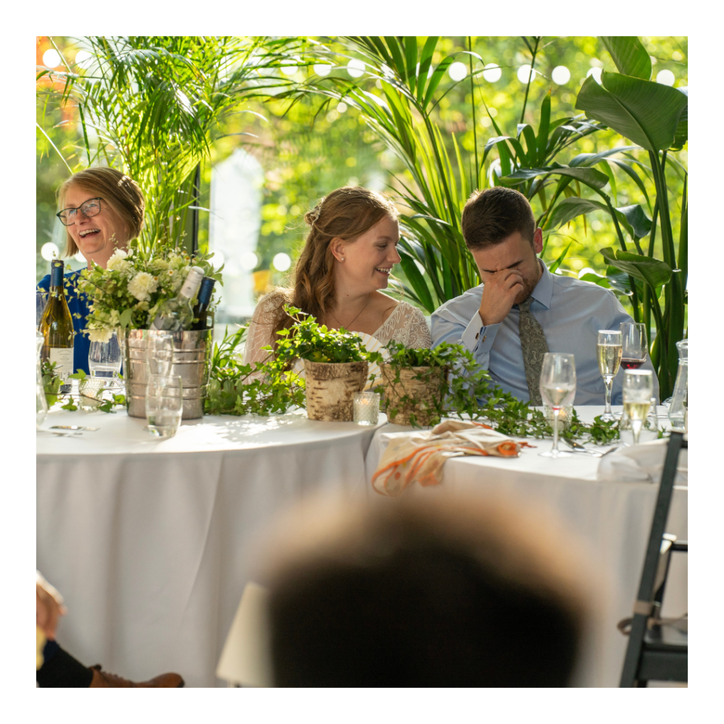 newly wed couple at the head table laughing